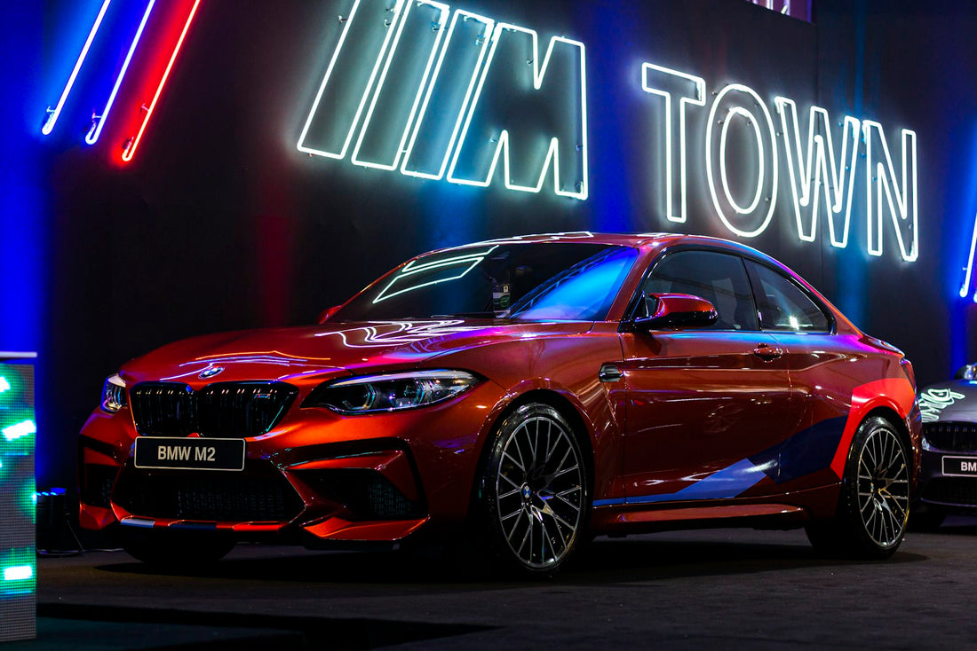 Red BMW M2 (F87) coupe parked outdoors, front three-quarter exterior view