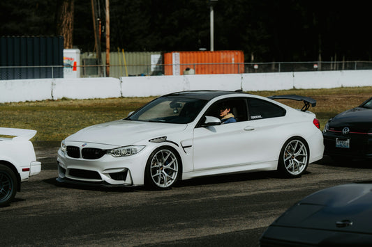 White BMW M4 driving on a race track circuit
