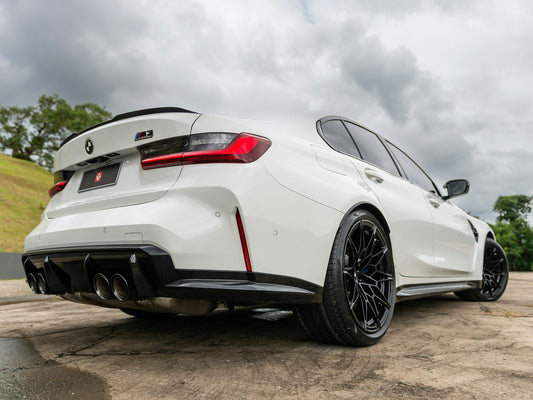White BMW M3 sports sedan on display at a car show, front three-quarter view